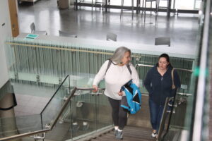 Two indigenous students from the Metis and Fort McKay First Nations climbing up the stairs in a common space on campus.