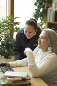 Two Indigenous students from the Stat'imc/Nlaka'pamux and Fort McKay First Nations studying by looking at something on a computer.