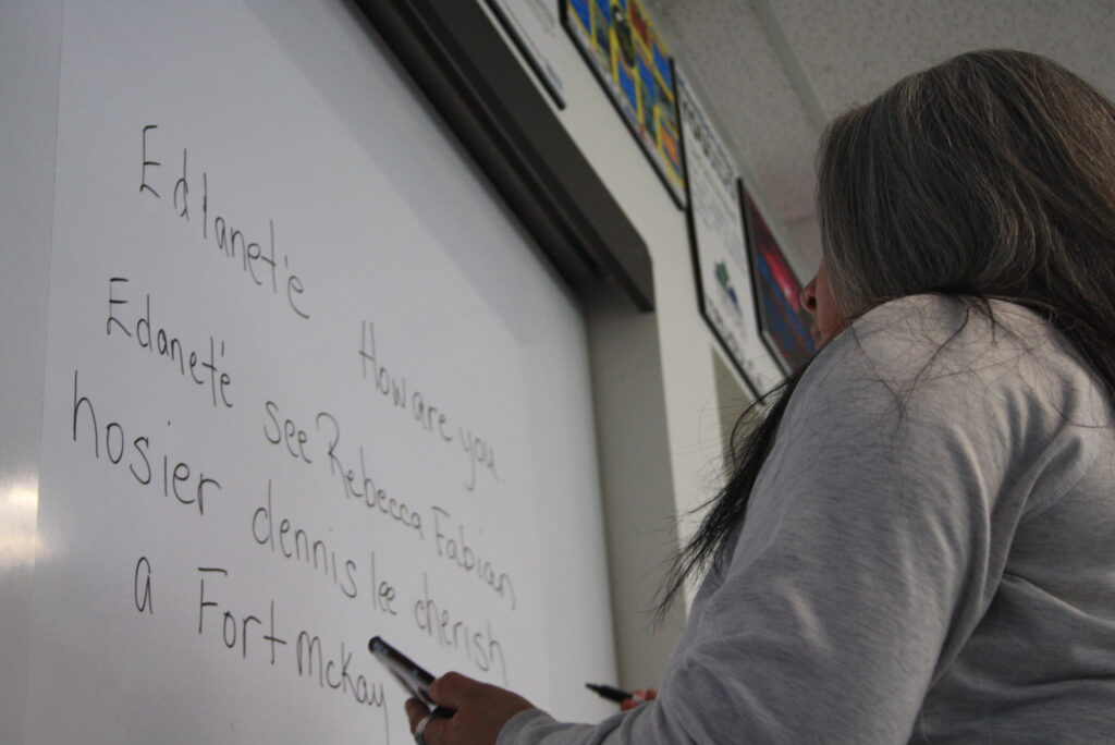 Indigenous teach from the Fort McKay First Nation teaching an Indigenous language using a whiteboard.