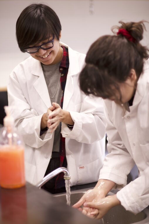 Indigenous students from the Ntekepmx Nation washing their hands in a science laboratory.