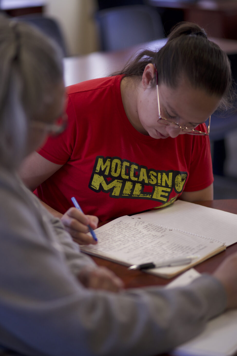 Two indigenous students from the Stat'imc/Nlakapamux and Fort McKay First Nations making some notes and studying at a common space on campus.